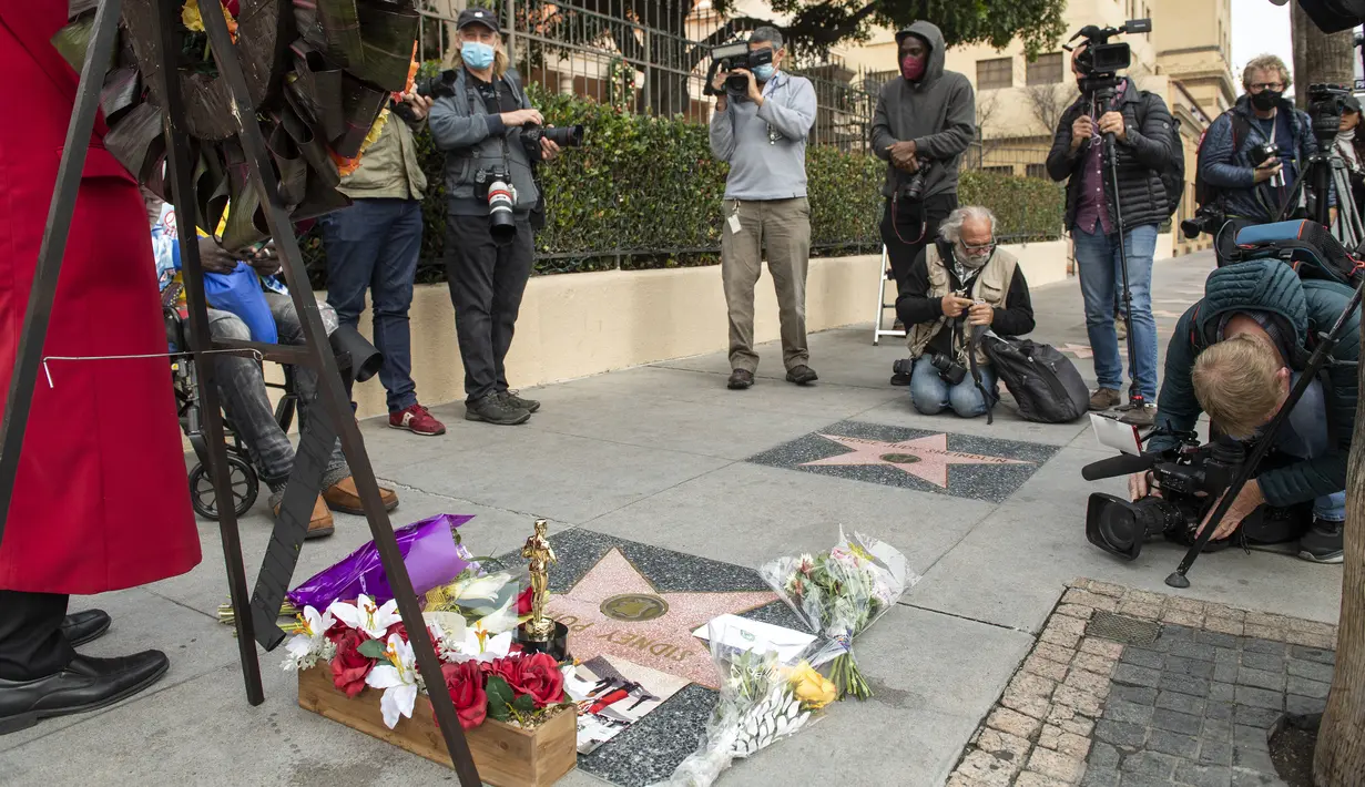 Jurnalis memotret dan memfilmkan bintang Sidney Poitier di Hollywood Walk of Fame di Hollywood, California, Jumat (7/1/2022). Poitier, bintang film kulit hitam pertama Hollywood dan pria kulit hitam pertama yang memenangkan aktor terbaik Oscar, meninggal pada usia 94 tahun. (VALERIE MACON/AFP)