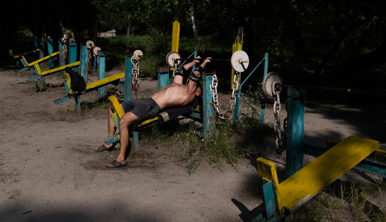 Jika tempat gym biasanya ada di dalam ruangan (indoor), tapi tidak dengan yang ada di Ukraina ini. Di Kiev,  ada sebuah tempat gym luar ruangan dan menggunakan besi tua sebagai peralatannya. (AP Photo/Jae C. Hong)