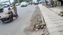Pedagang melintasi bekas galian gorong-gorong di Jalan Hayam Wuruk, Jakarta, Rabu (20/2). Tidak maksimalnya perbaikan pascapembongkaran gorong-gorong menyebabkan trotoar di kawasan itu rusak dan dipenuhi kerikil serta batu (Liputan6.com/Immanuel Antonius)