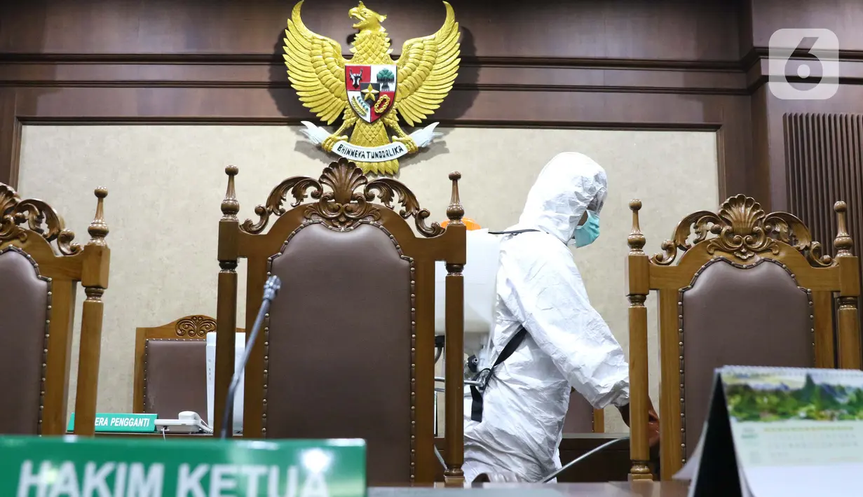 Petugas Palang Merah Indonesia saat melakukan penyemprotan cairan disinfektan di salah satu ruang sidang Pengadilan Negeri Jakarta Pusat, Rabu (18/3/2020). Penyemprotan cairan disinfektan untuk mencegah penyebaran virus corona COVID-19. (Liputan6.com/Helmi Fithriansyah)