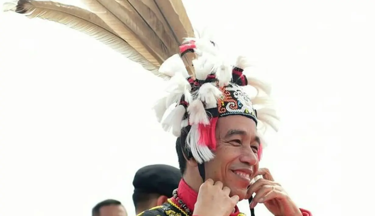 <p>Berkunjung ke Kabupaten Malinau, Kalimantan Utara, Jokowi mengenakan pakaian adat Dayak Kenyah berupa rompi hitam berhiaskan rangkaian manik-manik dan topi di Bandara Robert Atty Besing tahun 2019. (Instagram/Jokowi).</p>