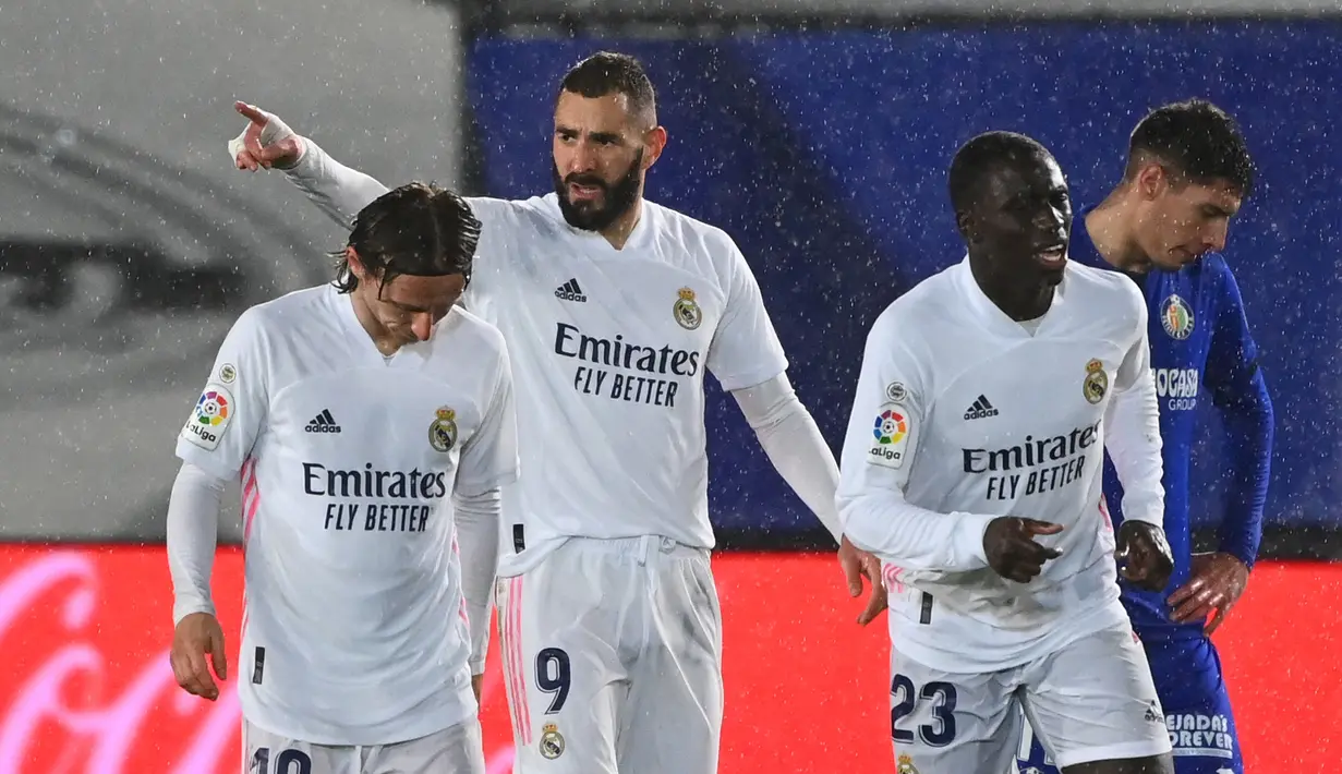 Striker Real Madrid, Karim Benzema (tengah) melakukan selebrasi usai mencetak gol pertama timnya ke gawang Getafe dalam laga lanjutan Liga Spanyol 2020/21 pekan ke-22 di Alfredo di Stefano Stadium, Selasa (9/2/2021). Real Madrid menang 2-0 atas Getafe. (AFP/Gabriel Bouys)