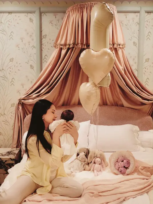 Dalam salah satu potret, Alyssa terlihat memeluk sang buah hati dengan penuh kasih sayang. Ia tampil santai mengenakan kemeja longgar berwarna butter yellow yang dipadukan dengan celana bernuansa krem. Rambut hitam panjangnya dibiarkan tergerai lurus dengan riasan natural yang membuat penampilannya terlihat effortless namun tetap menawan. [@alyssadaguise].