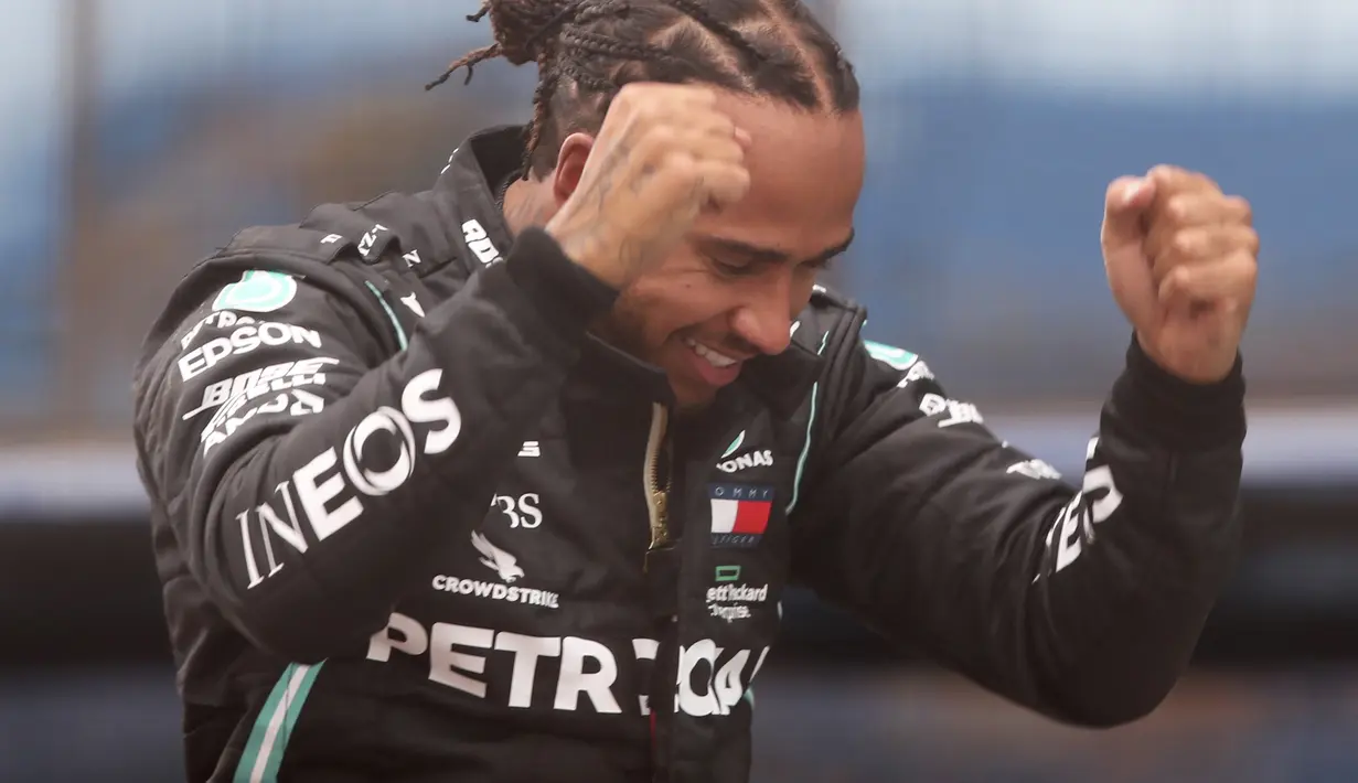 Pembalap Mercedes Lewis Hamilton dari Inggris berselebrasi setelah memenangkan Grand Prix Formula Satu Turki di arena pacuan kuda Istanbul Park di Istanbul, Minggu (15/11/2020). (Tolga Bozoglu/Pool via AP)