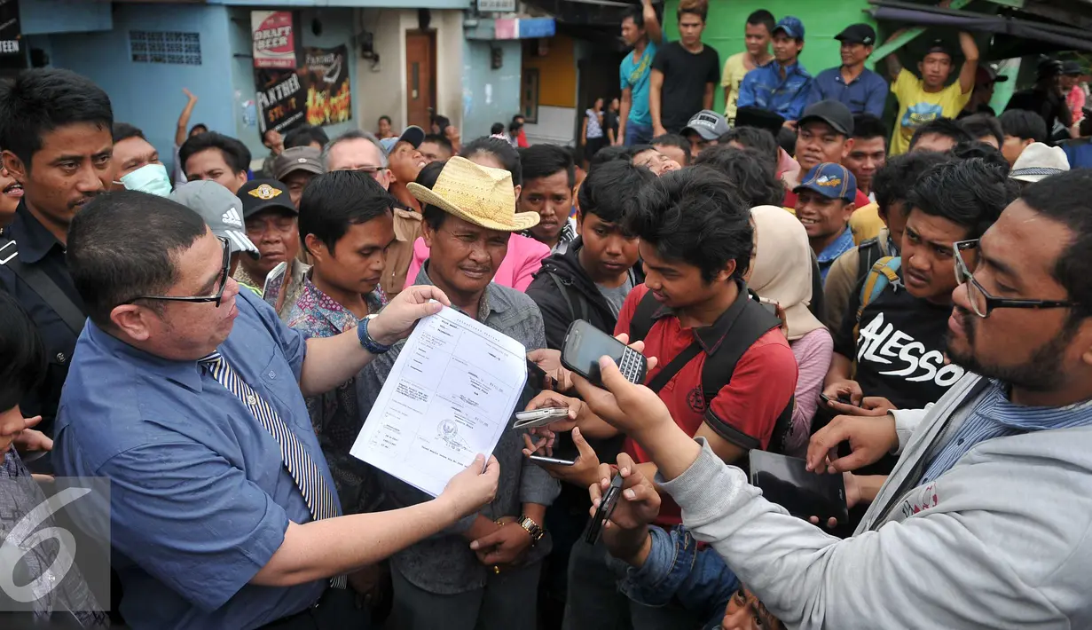 Kuasa Hukum Daeng Azis, Razman Nasution memperlihatkan surat pemberitahuan dari Pemprov DKI Jakarta yang tertempel di salah satu rumah di kawasan Kalijodo, Jakarta, Selasa (16/2). (Liputan6.com/Gempur M Surya)