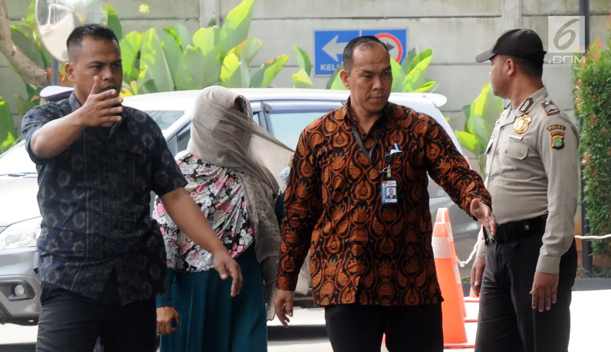 Kasi Dinkes Bengkulu Selatan Wati mendapat pengawalan petugas saat tiba di Gedung KPK, Jakarta, Rabu (16/5). Wati terjaring dalam OTT di rumah pribadi Bupati Bengkulu Selatan Dirwan Mahmud. (Merdeka.com/Dwi Narwoko)