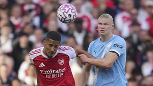 Pemain Arsenal, William Saliba (kiri), berduel dengan striker Man City, Erling Haaland, pada pekan 5 Liga Inggris 2025/2026 di Emirates Stadium, Minggu (21/9/2025) malam WIB. (AP Photo/Kin Cheung)