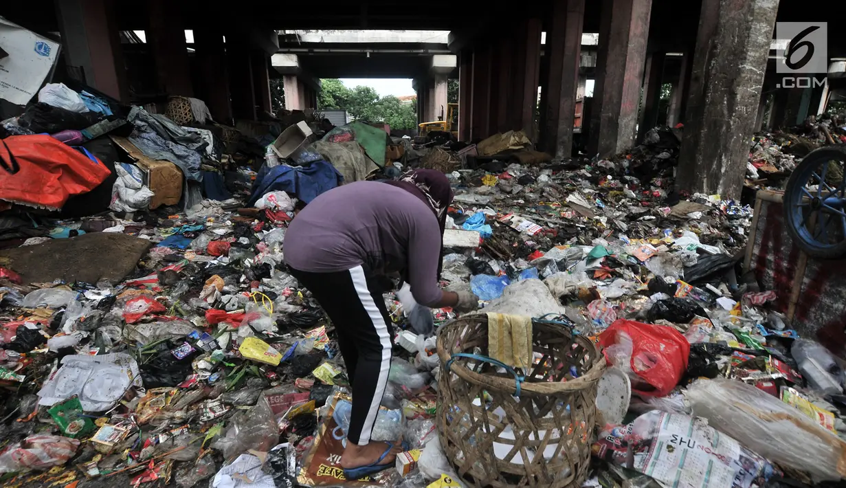 Pemulung memilah sampah di kolong Tol Wiyoto-Wiyono, Sungai Bambu, Jakarta, Selasa (15/1). Kolong Tol tersebut berubah menjadi tempat penampungan sampah warga di 3 kelurahan sehingga menyebabkan pencemaran lingkungan. (Merdeka.com/Iqbal S. Nugroho)