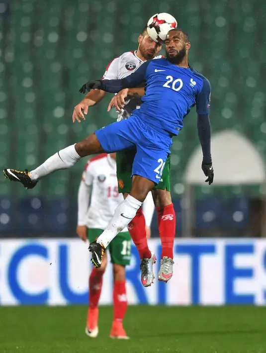 Pemain timnas Prancis, Alexandre Lacazette berebut bola dengan pemain Bulgaria, Nikolay Bodurov pada laga Kualifikasi Piala Dunia 2018 zona Eropa Grup A, Sabtu (7/10). Les Bleus unggul 1-0 lewat gol lewat gol Blaise Matuidi. (Dimitar DILKOFF / AFP)