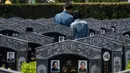 Peziarah berdoa dan memberikan penghormatan di depan makam keluarganya untuk menyambut festival Ching Ming di Shanghai (3/4). Untuk orang Tionghoa, perayaan ini dilakukan untuk mengingat dan menghormati nenek moyang. (AFP/Johannes Eisele)