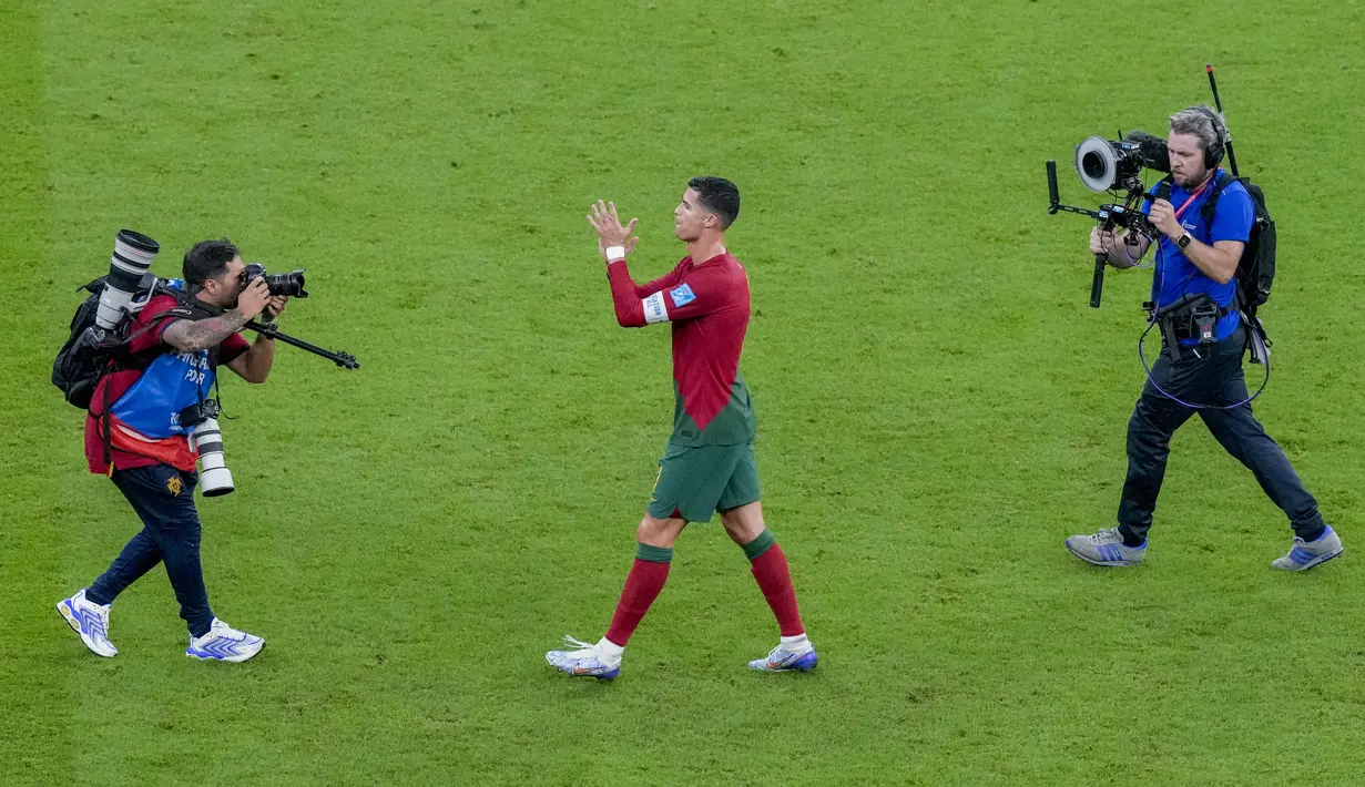 <p>Seorang fotografer memotret Cristiano Ronaldo bertepuk tangan pada akhir pertandingan babak 16 besar Piala Dunia antara Portugal dan Swiss, di Stadion Lusail di Lusail, Qatar, Selasa (6/12/2022). Ronaldo hanya bermain selama 17 menit. Dia tidak mencetak gol maupun assist. (AP Photo/Frank Augstein )</p>