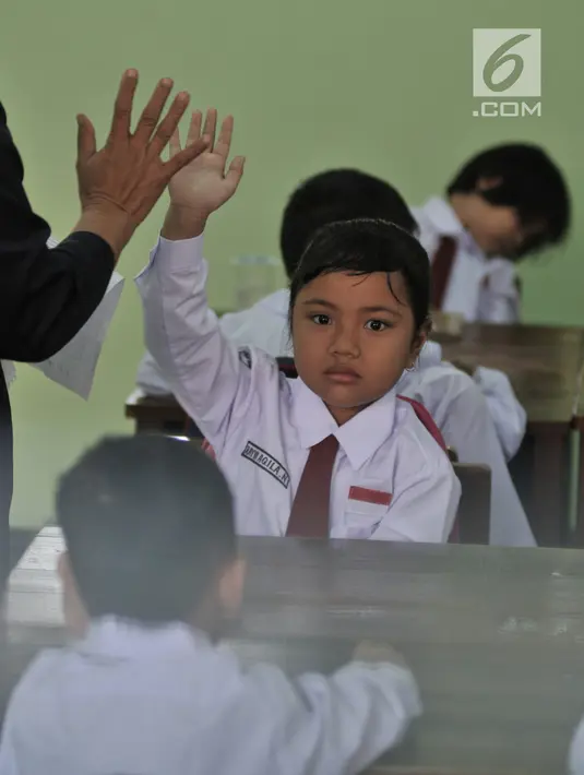 Ekspresi seorang murid siswa yang mengikuti aktivitas belajar mengajar di SDN Jatinegara Kaum 15 Pagi, Jakarta, Senin (15/7/2019). Sebanyak 32 anak menjadi murid baru SDN tersebut pada hari pertama masuk sekolah tahun ajaran 2019/2020. (merdeka.com/Iqbal S Nugroho)
