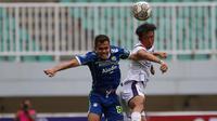 Pemain Persib Bandung, Rezaldi Hehanusa (kiri) berebut bola di udara dengan pemain Arema FC, Renshi Yamaguchi pada pertandingan pekan ke-26 BRI Liga 1 2022/2023 yang berlangsung di Stadion Pakansari, Bogor, Kamis (23/2/2023). (Bola.com/Ikhwan Yanuar)