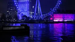 Cahaya biru menerangi objek wisata London Eye untuk berterima kasih kepada National Health Service (NHS) di London, Kamis (7/1/2021). NHS merupakan sistem layanan kesehatan nasional yang menjadi ujung tombak Inggris dalam memerangi pandemi Covid-19. (Tolga Akmen / AFP)