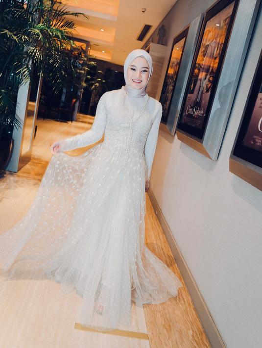Dinda Hauw tampil cantik dalam balutan gaun brukat dengan aksen outer lace berwarna nude [@dindahw]