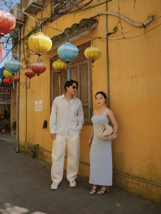 Di salah satu sudut kota tua yang terkenal dengan dinding kuning dan lampion warna-warni, Nikita tampil feminin dalam balutan midi dress sleeveless berwarna abu-abu lembut. [@nikitawillyofficial94].