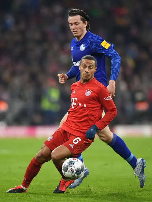 Gelandang Bayern Munchen, Thiago Alcantara mengontrol bola dari kawalan pemain Schalke, Michael Gregoritsch pada pertandingan Liga Jerman di Munich pada 25 Januari 2020. Thiago akan memakai nomor punggung 6 di Liverpool. (AFP/Christof Stache)