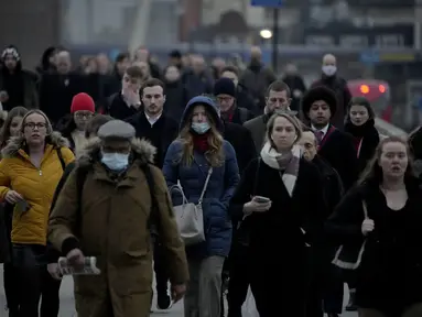 Pekerja berjalan di atas Jembatan London menuju distrik keuangan Kota London selama jam sibuk pagi hari, di London, Senin (24/1/2022). Pemerintah Inggris telah meminta orang-orang untuk kembali bekerja di kantor mulai Senin karena mereka melonggarkan pembatasan corona COVID-19. (AP Photo/Matt Dunham