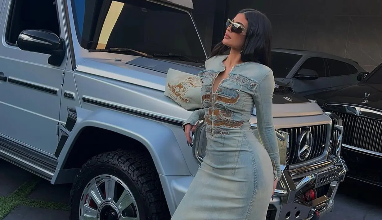 <p>Saat fashion Y2K sedang trend, Kylie pun ikut menggunakannya. Dress panjang bahan denim ini serasi dipasangkan dengan ankle boots motif kulit ular. [Instagram/kyliejenner]</p>