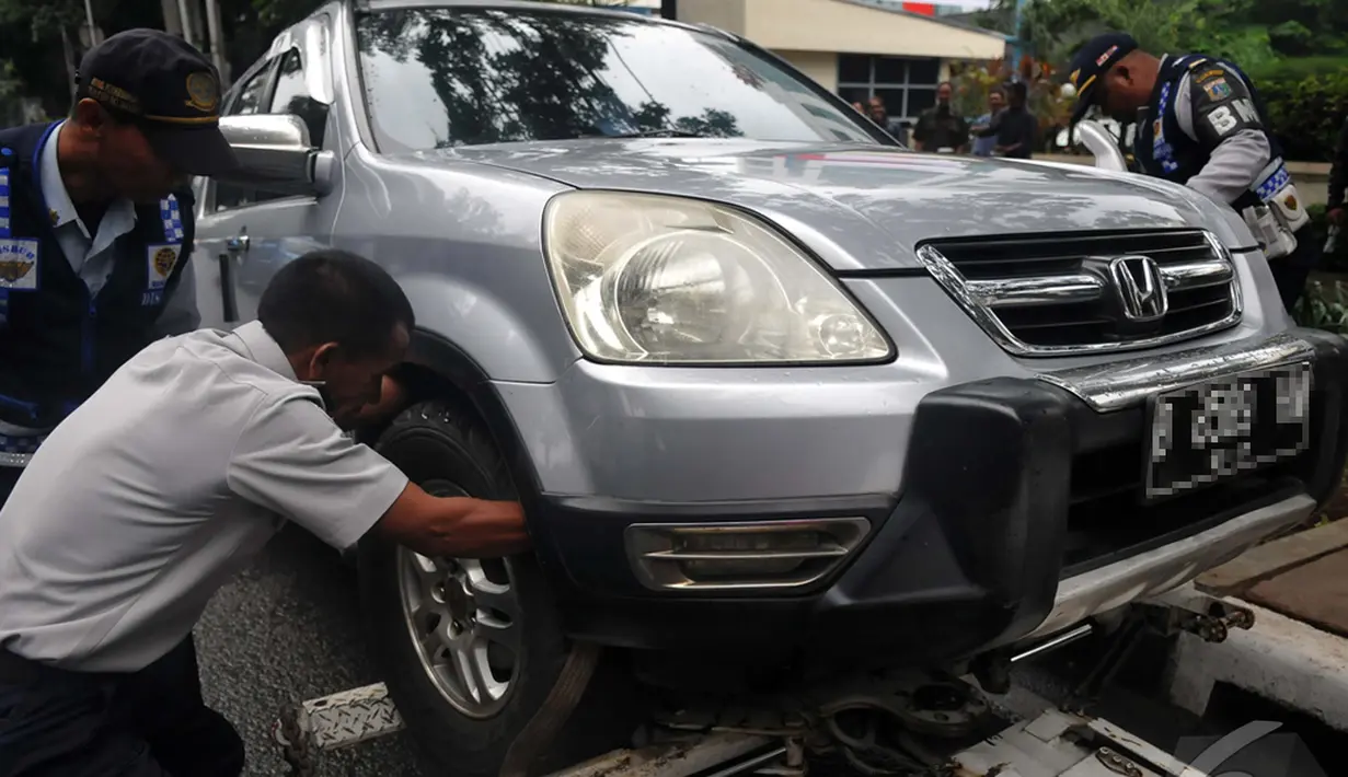 Di awal tahun 2015 Dinas Perhubungan DKI Jakarta terus melakukan sweeping agar pemilik kendaraan jera dengan pengangkutan dan pengempesan kendaraanya yang di parkir sembarangan, Jakarta, Senin (12/1/2015). (Liputan6.com/Johan Tallo)