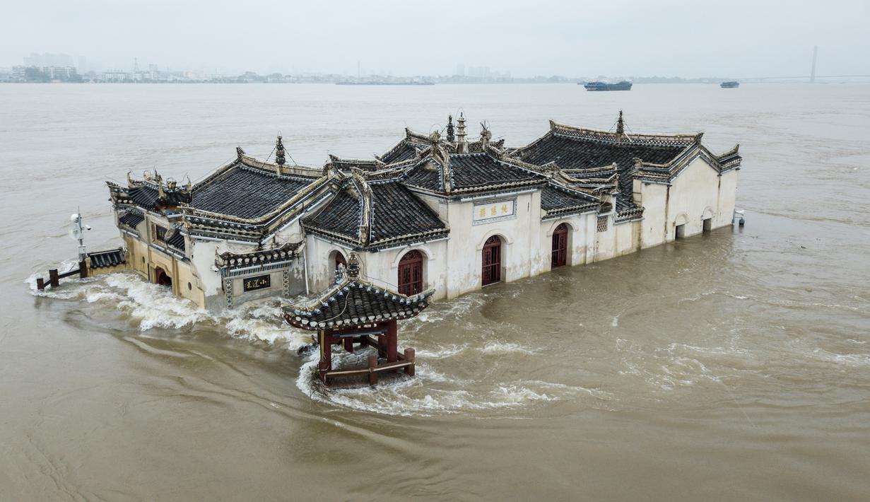 Foto pada 19 Juli 2020 menunjukkan kuil Guanyinge berumur 700 tahun yang dibangun di atas batu, terendam banjir akibat meluapnya sungai Yangtze di Wuhan, provinsi Hubei. Hujan lebat sejak bulan Juni telah menyebabkan sedikitnya 141 orang tewas dan memaksa hampir 15 juta orang dievakuasi. (STR/AFP)