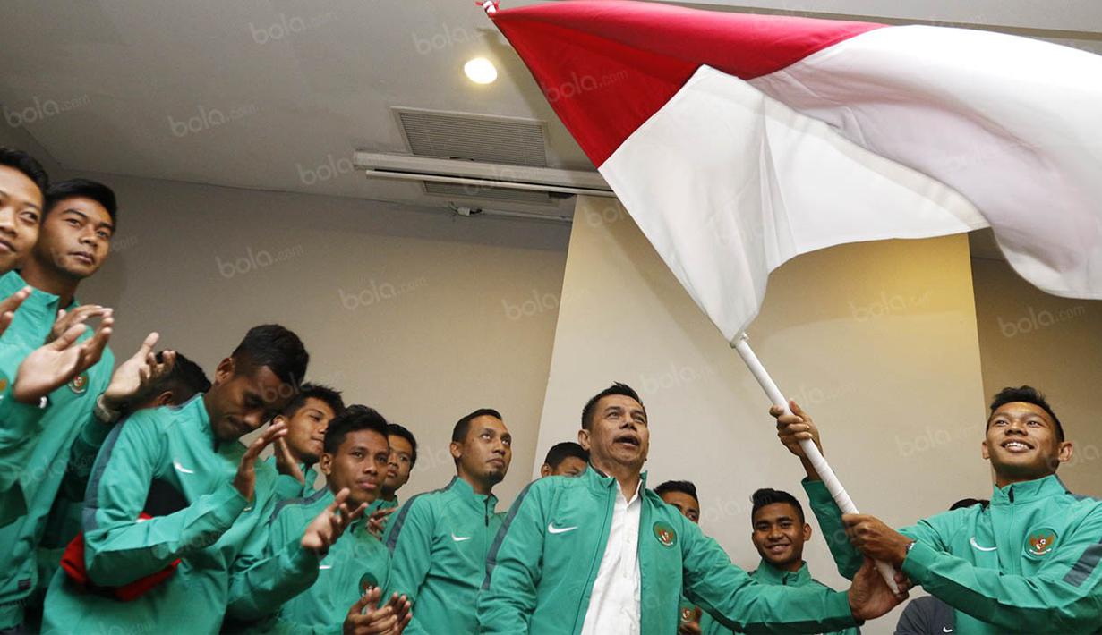 Kapten timnas Indonesia U-19, Andy Setyo Nugroho, mengibarkan bendera merah putih saat upacara pelepasan menuju Piala AFF U-19 2016 di Hotel Ibis Style, Tanggerang, Banten, Jumat (9/9/2016). (Bola.com/Vitalis Yogi Trisna)