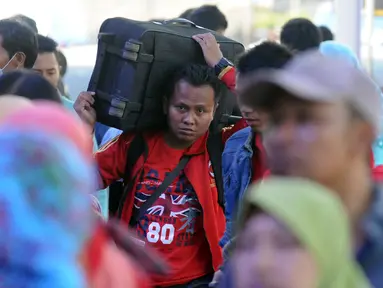 Seorang pemudik memanggul barang bawaannya di Stasiun Senen Jakarta, Sabtu (2/7). Ribuan pemudik kembali memadati Stasiun Senen untuk berangkat menuju kota kota di pulau Jawa. (Liputan6.com/Helmi Fithriansyah)