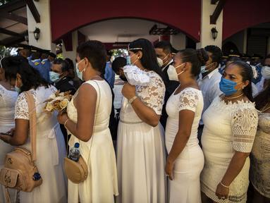 Pengantin berbaris sebelum nikah massal pada Hari Valentine, di Taman Paseo Xolotlan di Managua, Nikaragua, Minggu (14/2/2021). Sebanyak 400 pasangan dari kalangan tidak mampu di Nikaragua melaksanakan nikah massal gratis yang diselenggarakan Mahkamah Agung dan stasiun radio lokal. (Inti OCON/AFP)