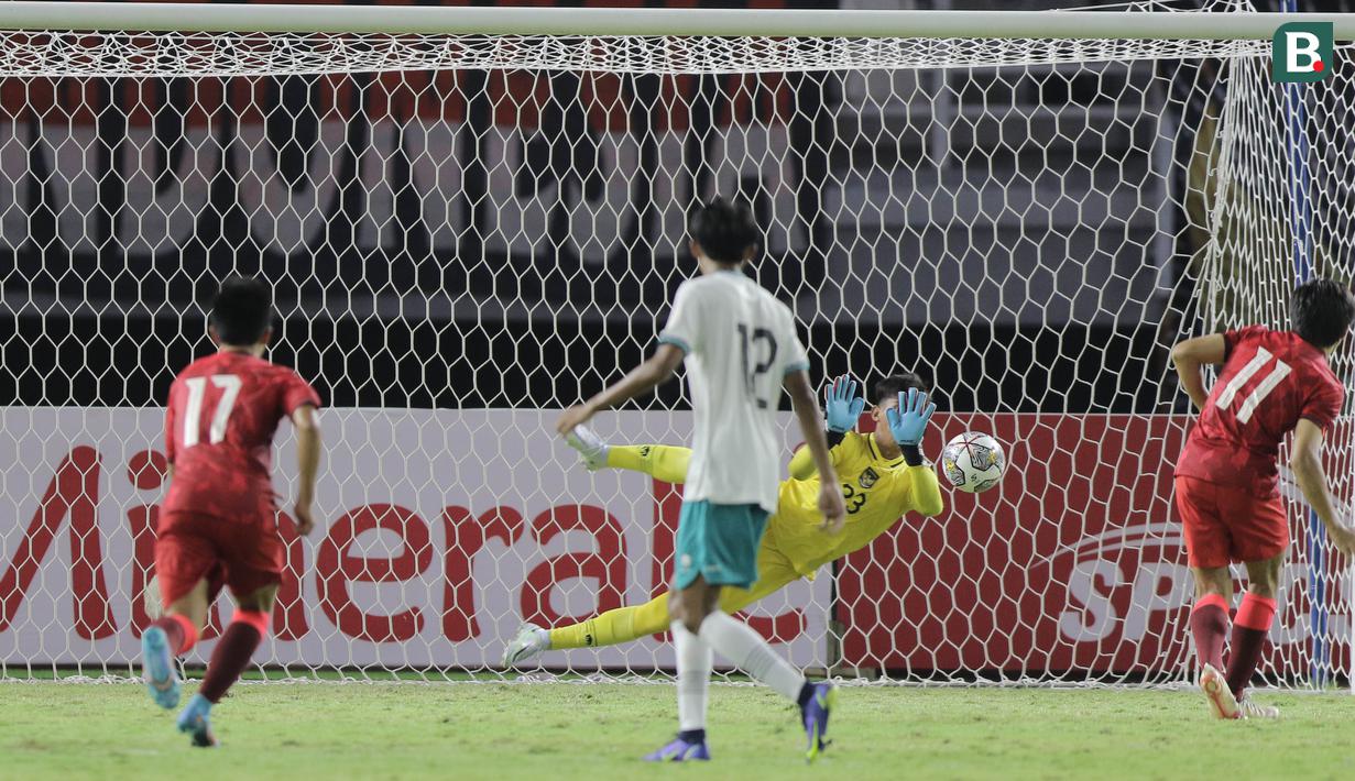 Kiper kelima milik Persebaya Surabaya tersebut berhasil menebak arahnya bola dan menepis dari tendangan Chen Ngo Hin. (Bola.com/Ikhwan Yanuar)