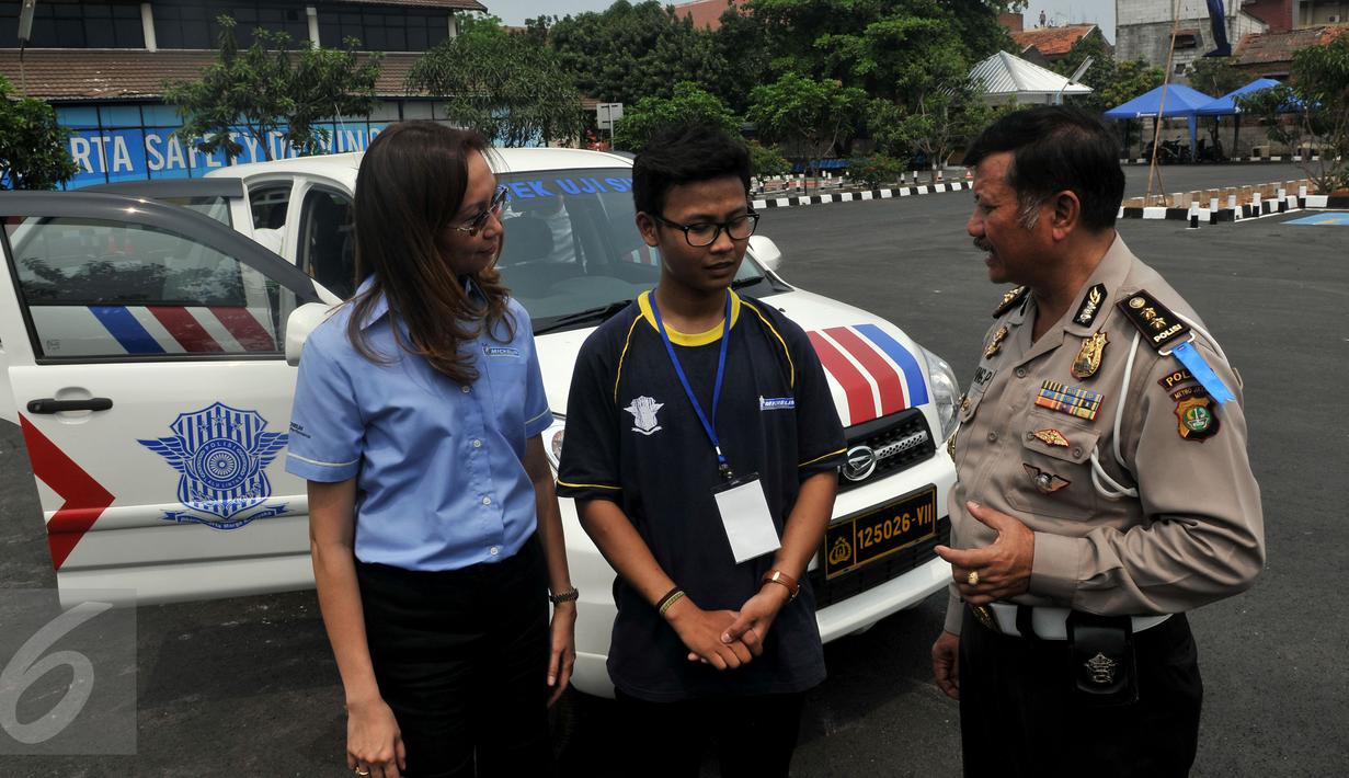 Kasubdit Dikyasa Polda Metro Jaya AKBP Ipung Purnama bersama  Public Affairs PT Michelin Indonesia Nora Guitet memberikan pengarahan kepada siswa sebelum melakukan ujian praktek membawa mobil di Samsat, Jakarta,(1/11/2015). (Liputan6.com/Johan Tallo)