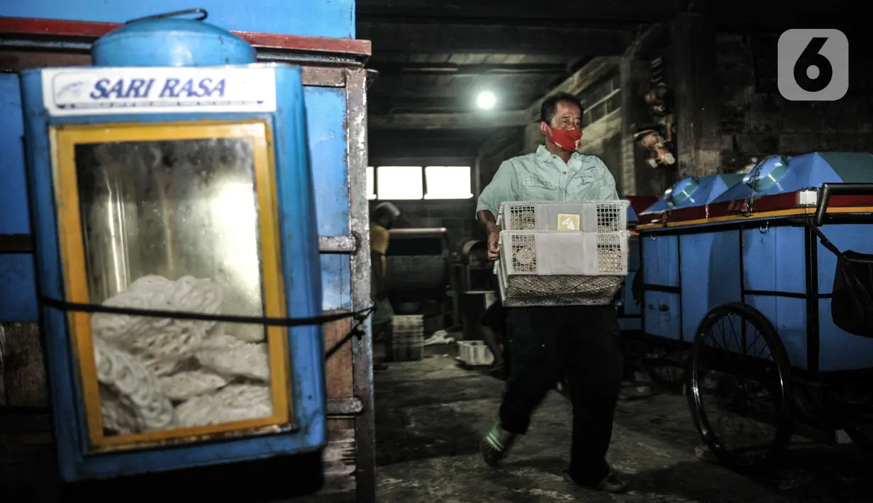 Pekerja mengangkut kerupuk untuk digoreng di industri rumahan kawasan Cipinang Melayu, Jakarta, Selasa (16/2/2021). Selama pandemi corona, jumlah produksi di industri rumahan ini dikurangi dari 10.000 kerupuk per hari, kini hanya 5.000 kerupuk tiap harinya (merdeka.com/Iqbal S Nugroho)