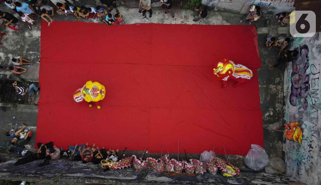 Foto udara memperlihatkan pemain dari kelompok barongsai Naga Merah Putih Bogor melakukan latihan dengan Barongsai di kawasan Babakan Pasar, Kota Bogor, Jawa Barat, Rabu (11/1/2023). Latihan tersebut  untuk mempersiapkan penampilan menyambut Tahun Baru Imlek. (Liputan6.com/Herman Zakharia)