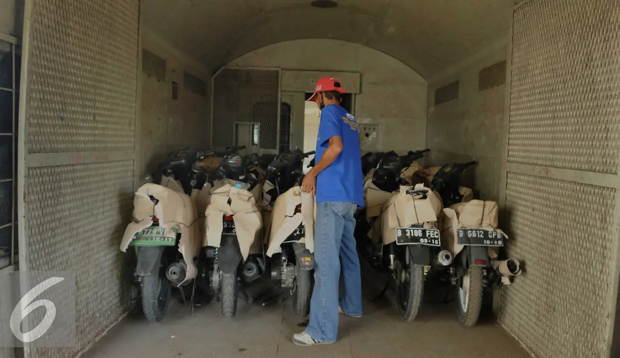 Pekerja memasukkan sepeda motor yang akan dikirim melalui angkutan kereta api di Stasiun Jakarta Gudang, Jakarta, Selasa (28/6). Total kapasitas angkut sepeda motor tahun ini mencapai 15.834 motor. (Liputan6.com/Gempur M Surya)