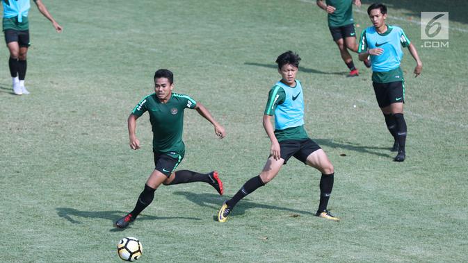 Pemain Timnas Indonesia U-19, Nur Hidayat (kiri) berebut bola dengan Febri Eka saat latihan di Lapangan B Kompleks GBK, Jakarta, Selasa (18/9). Latihan ini persiapan  PSSI Anniversary Cup U-19 dan Piala AFC U19. (Liputan6.com/Helmi Fithriansyah)