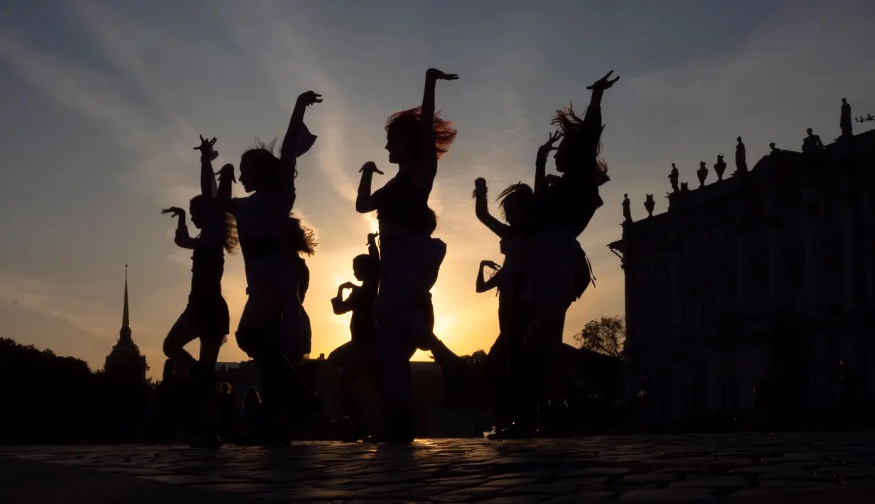 Para wanita muda menari tarian kelompok saat matahari terbenam di Palace Square, St. Petersburg, Rusia, Kamis (24/9/2020). (AP Photo/Dmitri Lovetsky)