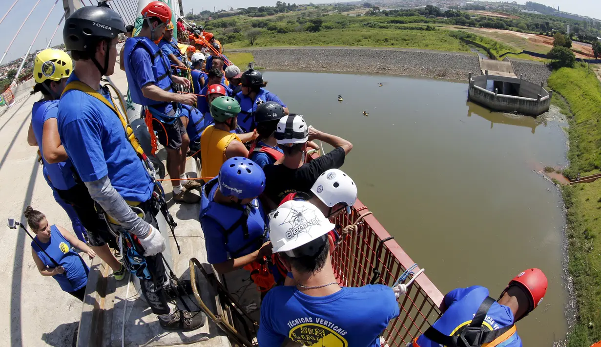 Sejumlah orang mempersiapkan diri untuk melompat dari atas jembatan dengan ketinggian 30 meter di Hortolandia, Brasil, Minggu (10/4). Sebanyak 149 orang mencoba membuat rekor dunia dengan melompat bersama dari atas jembatan. (REUTERS/Paulo Whitaker)