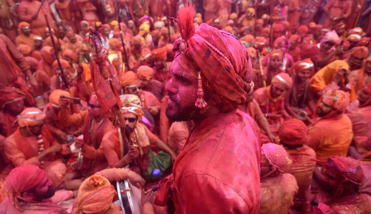 Umat Hindu merayakan Holi, festival warna musim semi, di sebuah kuil di desa Nandgaon, negara bagian Uttar Pradesh, 5 Maret 2020. Ribuan orang India menyambut musim semi pada Kamis (5/3) dengan merayakan Festival Holi yang identik dengan aksi saling melemparkan bubuk warna warni. (Money SHARMA/AFP)