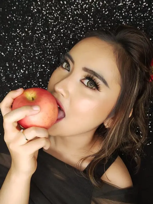 Pasang pose sedang menggigit apel, pesona Lebby Wilayati begitu terpancar dalam pemotretan ini. Meski mengenakan makeup simpel dan rambut dikuncir, penyanyi dangdut ini tampak begitu memesona. (Liputan6.com/IG/@lebbywilayati)