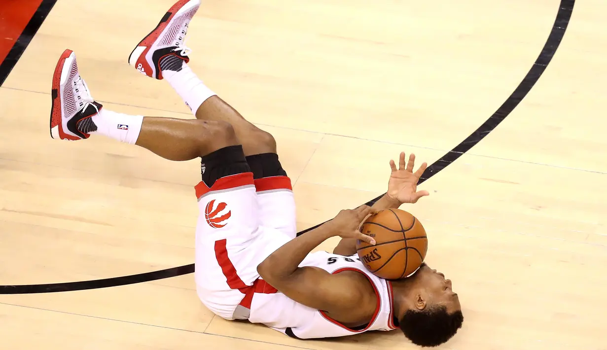 Pemain Raptors, Kyle Lowry #7 terjatuh saat berebut bola dengan para pemain Cleveland Cavaliers pada final Wilayah Timur NBA Playoffs 2016 di Air Canada Centrer, Selasa (24/5/2016), Toronto, Ontario, Canada. (Tom Szczerbowski/Getty Images/AFP)