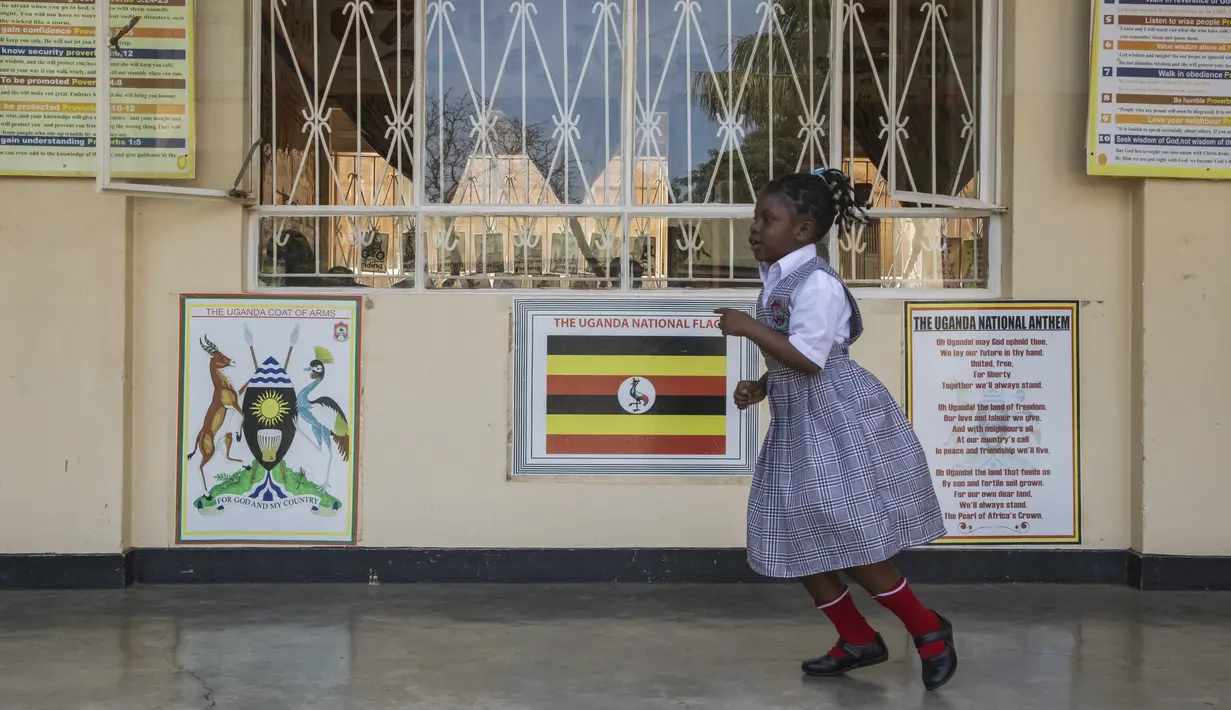 Seorang Siswa berlari di beranda koridor ruang kelas pada hari pertama pembukaan sekolah di Kampala, Uganda pada 10 Januari 2022. Sekolah-sekolah di Uganda dibuka kembali untuk siswa pada Senin (10/1), mengakhiri penutupan sekolah terlama di dunia akibat pandemi COVID-19. (Badru KATUMBA/AFP)