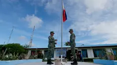  Tentara Filipina menaikan bendera saat mengikuti upacara di Pulau Thitu, Kepulauan Spratly, Laut China Selatan, Jumat (21/4). Pengibaran bendera Filipina yang sebelumnya dibatalkan  Presiden Duterte  akhirnya dilaksanakan. (AP Photo / Bullit Marquez)
