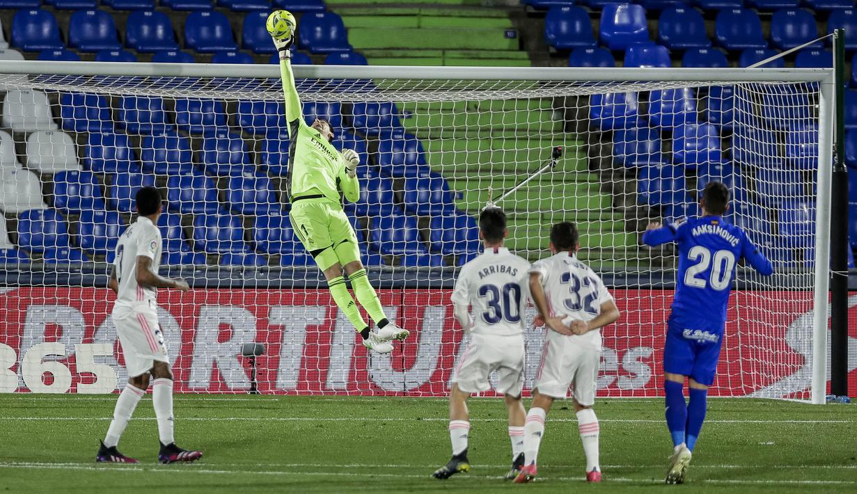 Kiper Real Madrid, Thibaut Courtois, berusaha menghalau bola saat melawan Getafe pada laga Liga Spanyol di Stadion Alfonso Perez, Senin (19/4/2021). Kedua tim bermain imbang 0-0. (AP Photo/Manu Fernandez)