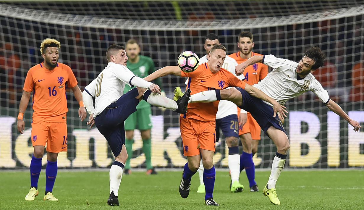 Gelandang Belanda, Jens Toornstra, dihadang oleh Gelandang Italia, Marco Parolo, pada laga persahabatan di Stadion Amsterdam Arena, Belanda, (28/03/2017). Italia berhasil menang 2-1 atas Belanda (AFP/John Thys)