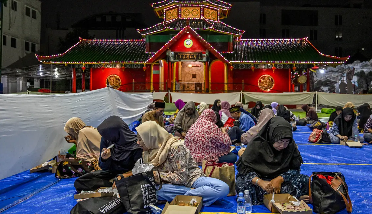 Umat Muslim menikmati sajian berbuka puasa saat bulan suci Ramadan di Masjid Muhammad Cheng Hoo, Surabaya pada Kamis 6 Maret 2025. (Juni KRISWANTO/AFP)