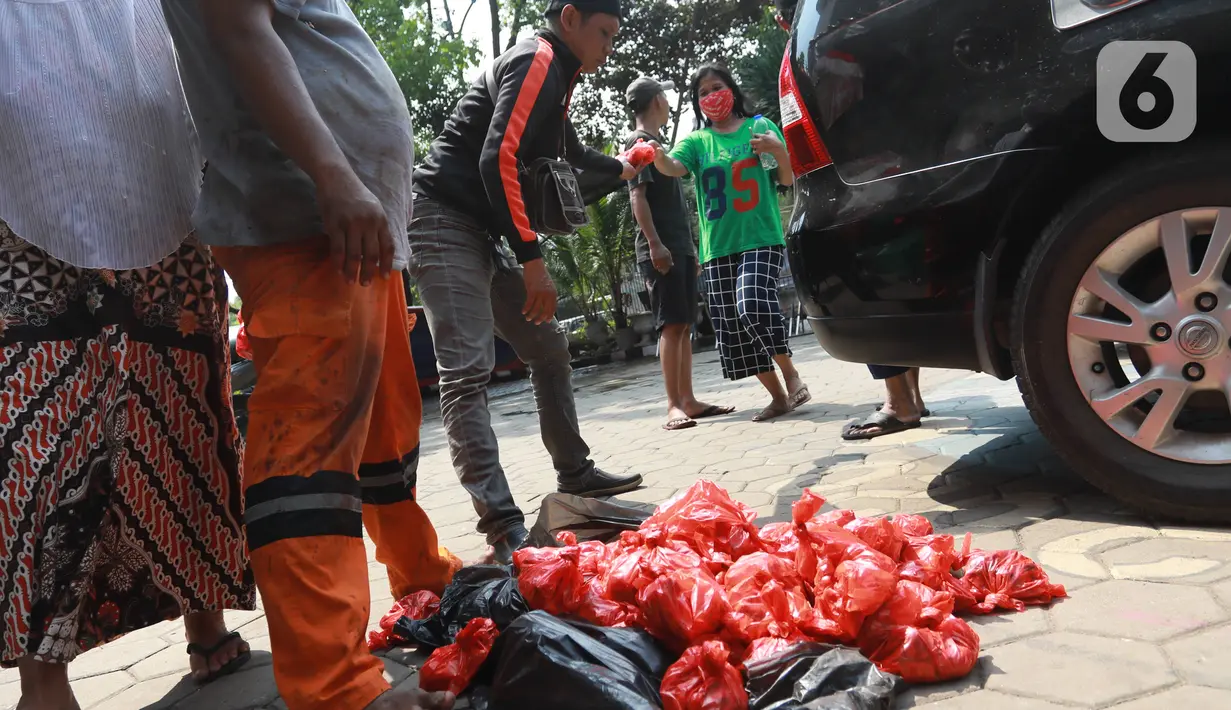 Panitia membagikan daging kurban kepada warga di Kelurahan Menteng, Jakarta Pusat, Sabtu (1/8/2020). Pembagian daging kurban tersebut berjalan lancar meskipun sebagian warga mengabaikan protokol Kesehatan. (Liputan6.com/Angga Yuniar)