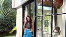 Padu padan pakai jeans tetap terlihat feminin ala Mici. Ia memadukan crop top bercorak garis tanpa lengan dengan celana jeans berkantung. [Foto: Instagram/parramitha]