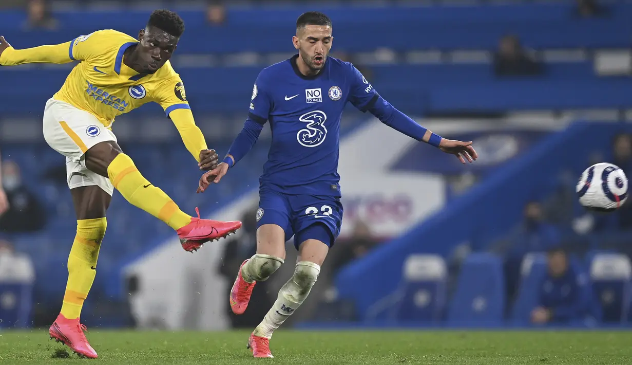 Gelandang Brighton and Hove Albion, Yves Bissouma (kiri) melepaskan tendangan di depan gelandang Chelsea, Hakim Ziyech dalam laga lanjutan Liga Inggris 2020/2021 pekan ke-32 di Stamford Bridge, London, Selasa (20/4/2021). Chelsea bermain imbang 0-0 dengan Brighton. (AP/Neil Hall/Pool)