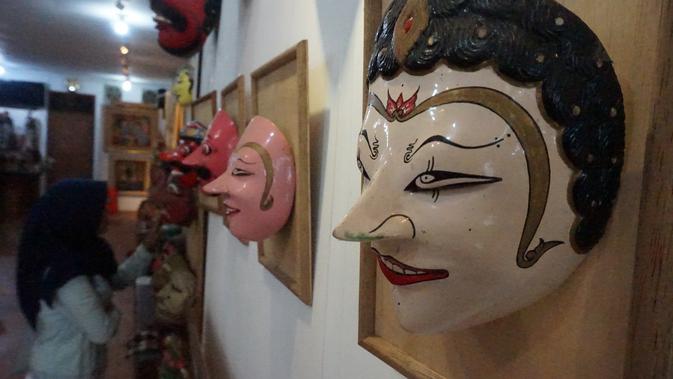 Pengunjung sedang memerhatikan koleksi topeng di Galeri Seni Abun. (Liputan6.com/Huyogo Simbolon)