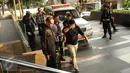 Dua tersangka hasil OTT KPK menutup wajahnya saat turun dari mobil dan digiring masuk ke gedung KPK Jakarta, Sabtu (20/6/2015). KPK mengamankan empat orang hasil OTT yang berlangsung pada Jumat (19/6) malam di Palembang. (Liputan6.com/Helmi Fithriansyah)
