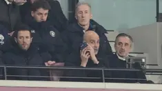 Pelatih Manchester City, Pep Guardiola, memberikan arahan melalui telpon dari tribun penonton saat anak asuhnya bermain imbang 1-1 melawan West Ham United pada pekan ke-30 Premier League 2025/2026 di London Stadium pada Minggu (15/3/2026). (AP Photo/Dave Shopland)
